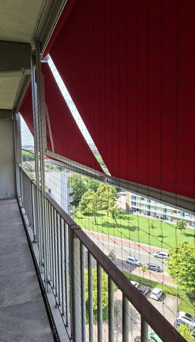 Net rondom balkon met zonnescherm in Den Haag